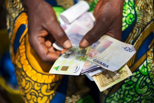 e-zwich-Karte und Banknoten in den Händen einer Frau aus Ghana