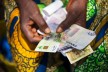 e-zwich-Karte und Banknoten in den Händen einer Frau aus Ghana