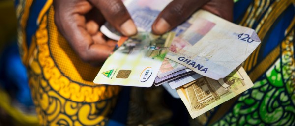 e-zwich-Karte und Banknoten in den Händen einer Frau aus Ghana