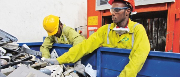 Zwei Arbeiter durchsuchen einen Container mit Elektroschrott