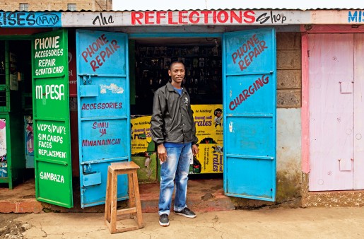 Ein Mann steht vor einem Laden, in dem verschiedene Handy-Services angeboten werden