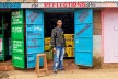 Ein Mann steht vor einem Laden, in dem verschiedene Handy-Services angeboten werden