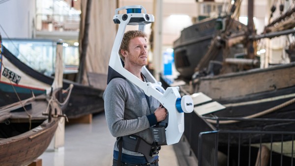 man with mobile mapping system in a warehouse with boats.