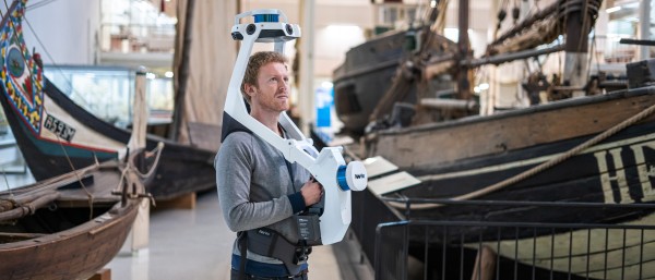 man with mobile mapping system in a warehouse with boats.