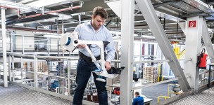 A man in a production hall aligns a mobile mapping system.