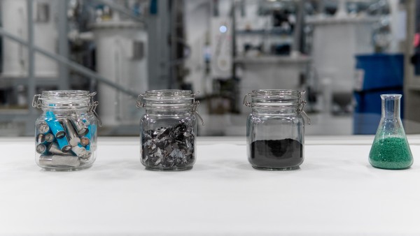 vier Gläser gefüllt mit verschiedenen Bestandteilen von Batterien