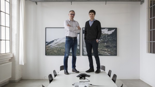 Rhebo-Gründer Frank Stummer und Klaus Mochalski stehen auf einem Konferenztisch
