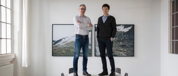 Rhebo-Gründer Frank Stummer und Klaus Mochalski stehen auf einem Konferenztisch