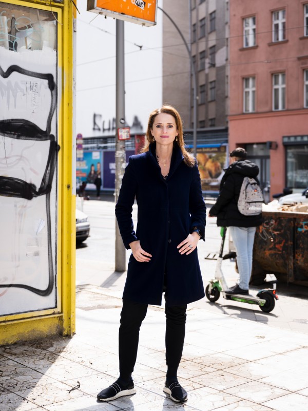 Verena Pausder stands on a street corner smiling friendly