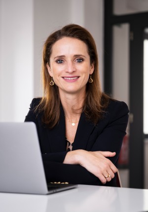 Verena Pausder sitzt lächelnd vor ihrem Notebook