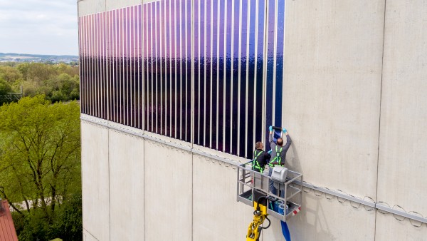 Zei Männer kleben Solarfolien auf ein Hauswand