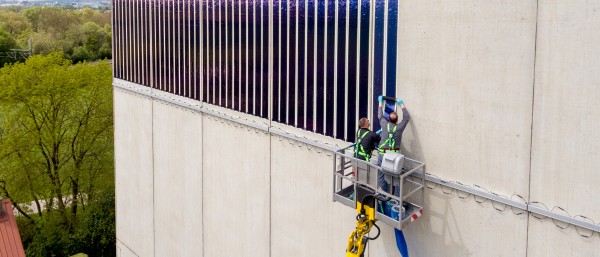 Two man attaching solarfilms onto a wall