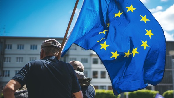 Mann mit einer Europafahner über seiner Schulter während einer Kundgebung