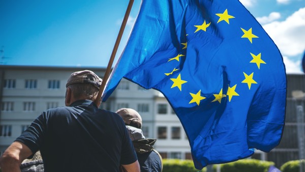 Man with a European flag over his shoulder during a rally