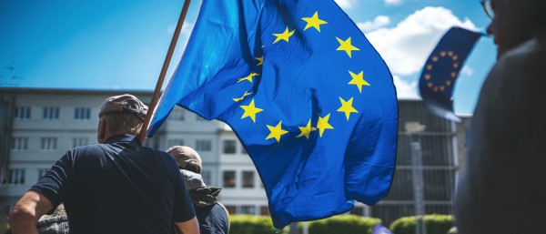 Mann mit einer Europafahner über seiner Schulter während einer Kundgebung