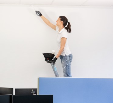 Eine Mitarbeiterin von Reise Leitner streicht die Wand