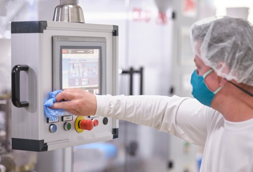 An UniCaps employee disinfects a screen