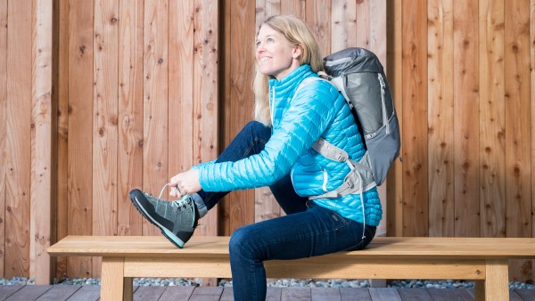 Vaude-Geschäftsführerin Antje von Dewitz sitzt auf einer Bank und schnürt ihren Schuh