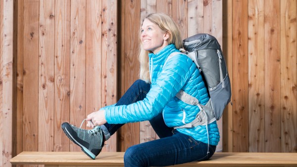 Vaude-Geschäftsführerin Antje von Dewitz sitzt auf einer Bank und schnürt ihren Schuh