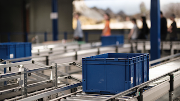 Blaue Kästen werden auf Förderbändern transportiert